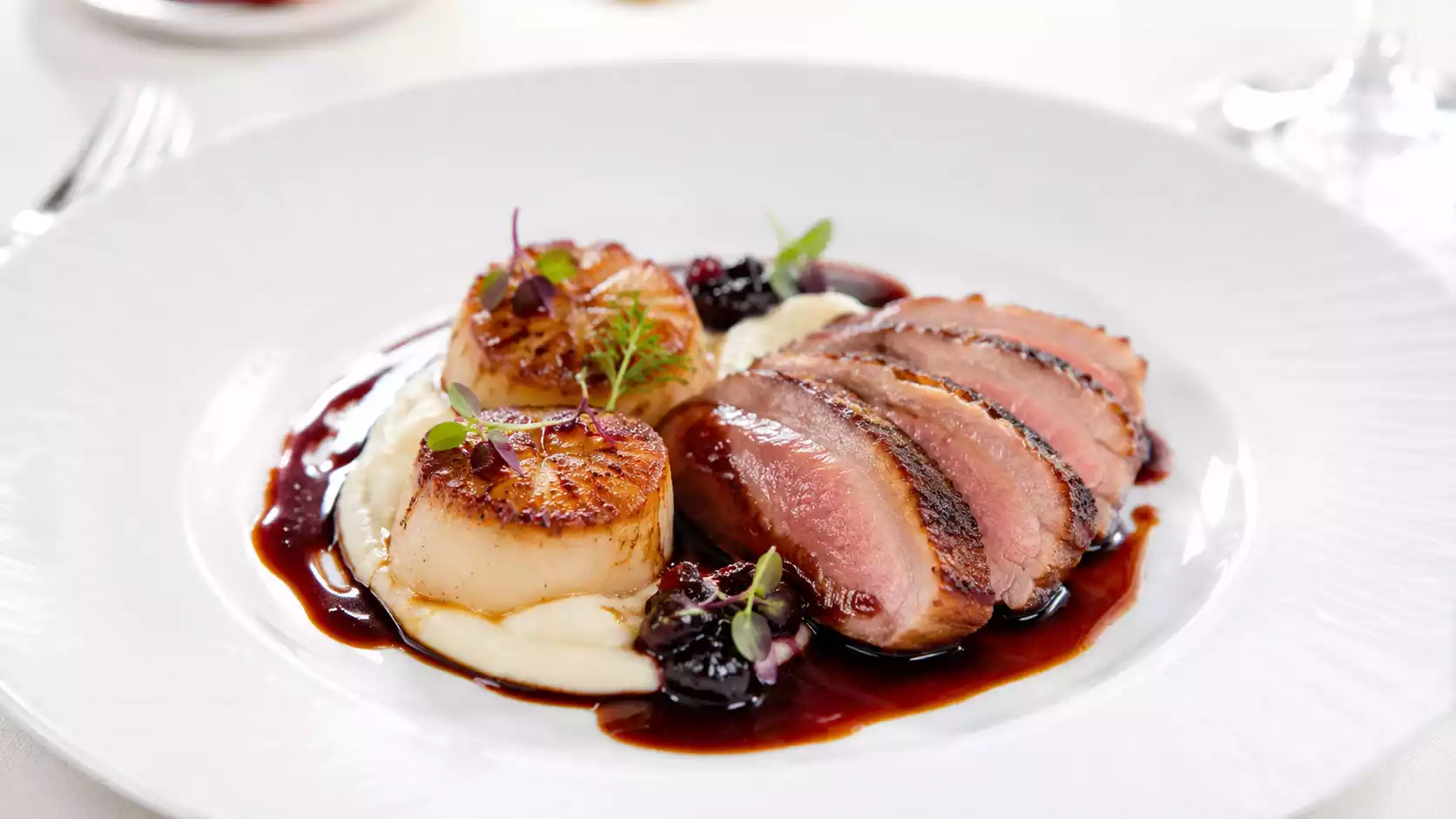 Duo mer et terre : Saint-Jacques poêlées et magret de canard
